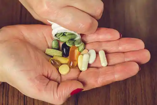 Woman holding different capsules in her hand